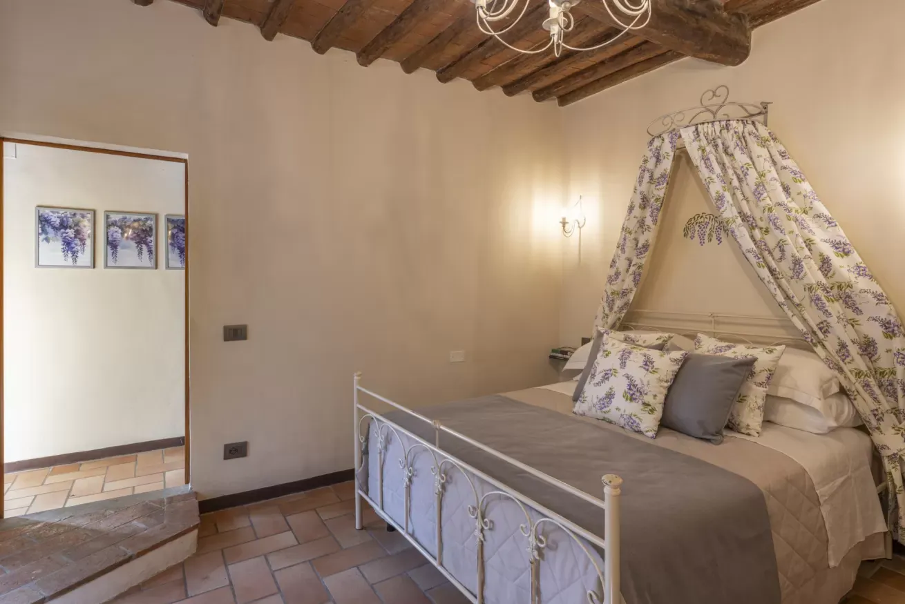 Camera da letto con letto a baldacchino e soffitto con travi in legno