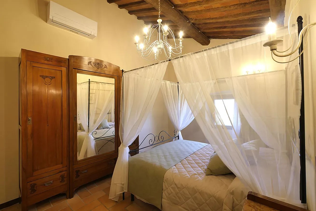 Camera da letto rustica con letto a baldacchino, armadio in legno e lampadario