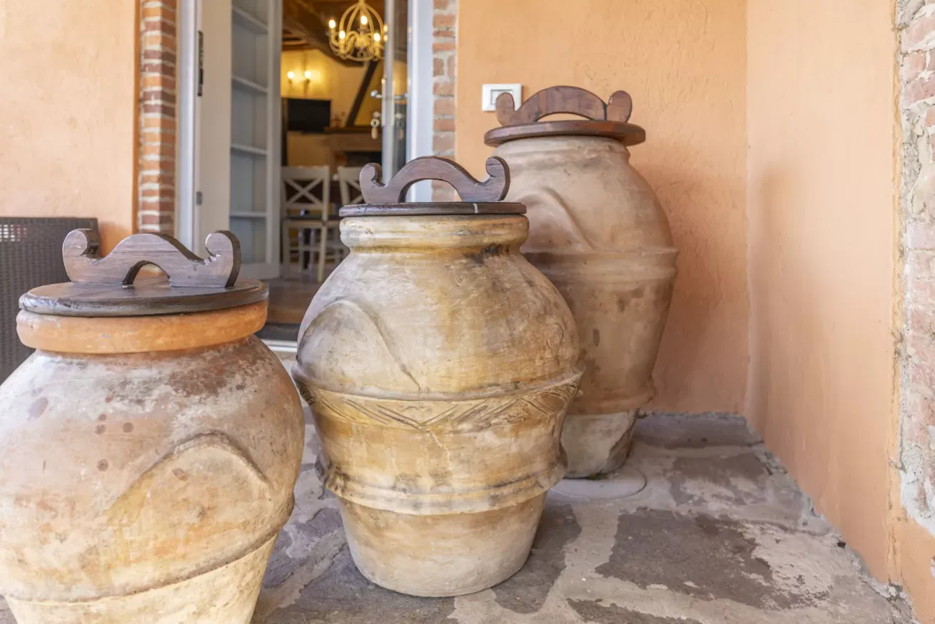 Tre grandi anfore decorative in terracotta davanti a un ingresso