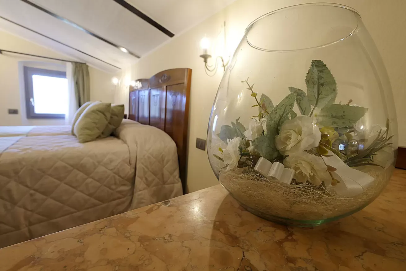 Composizione floreale in una sfera di vetro su un tavolo, con una camera da letto sullo sfondo