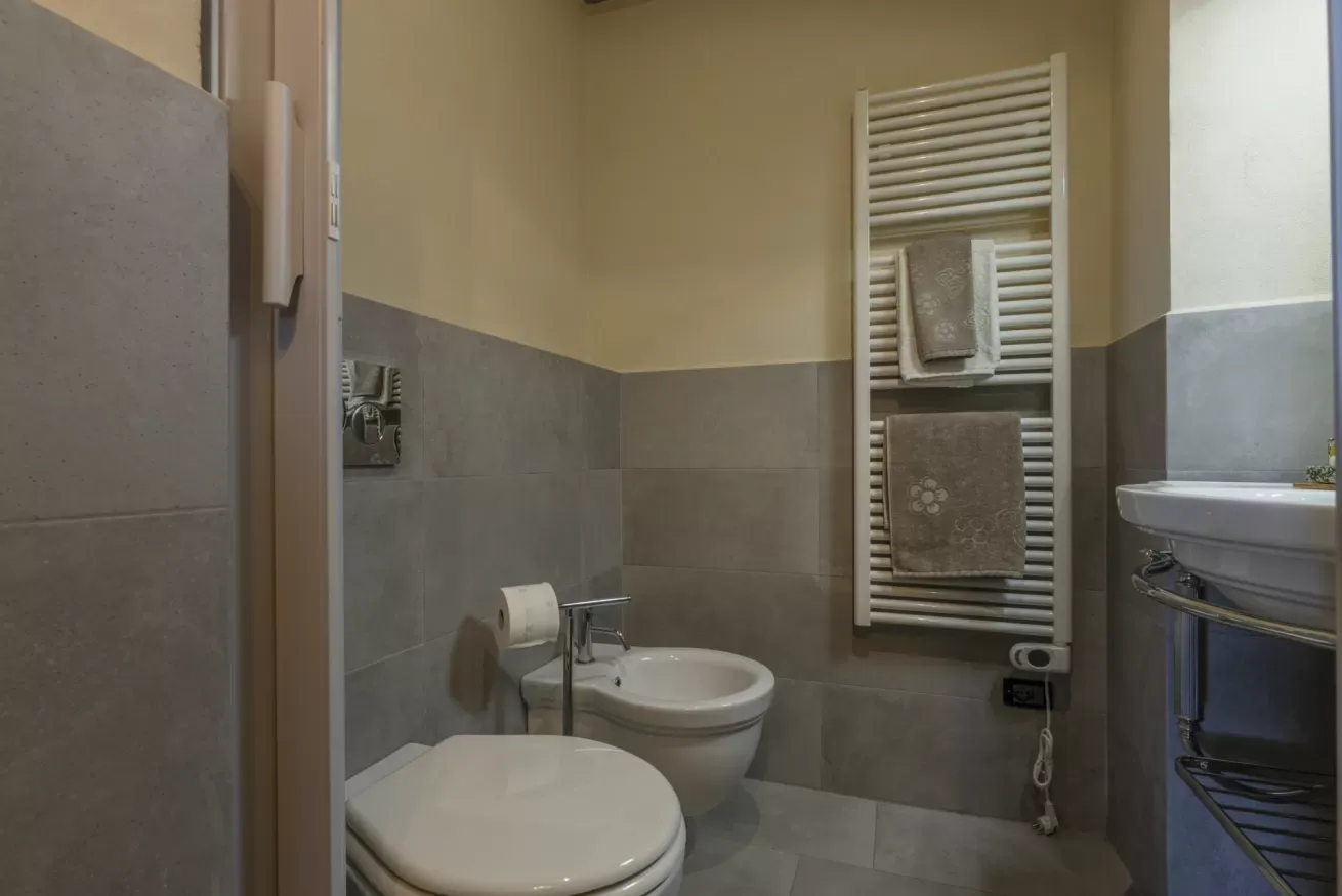 Bagno con WC, bidet, lavabo e scaldasalviette con asciugamani
