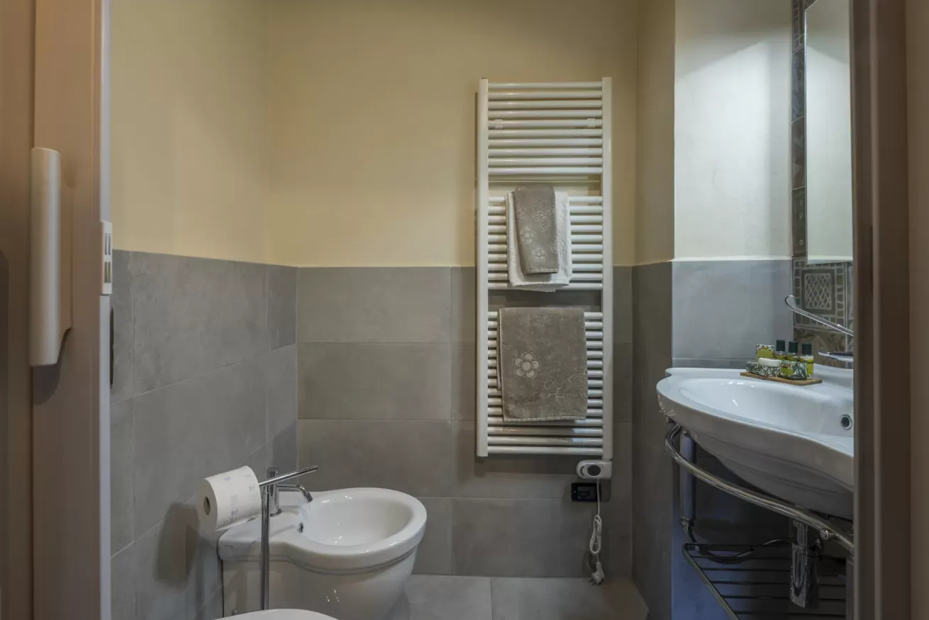 Bagno con bidet, lavabo e termoarredo con asciugamani