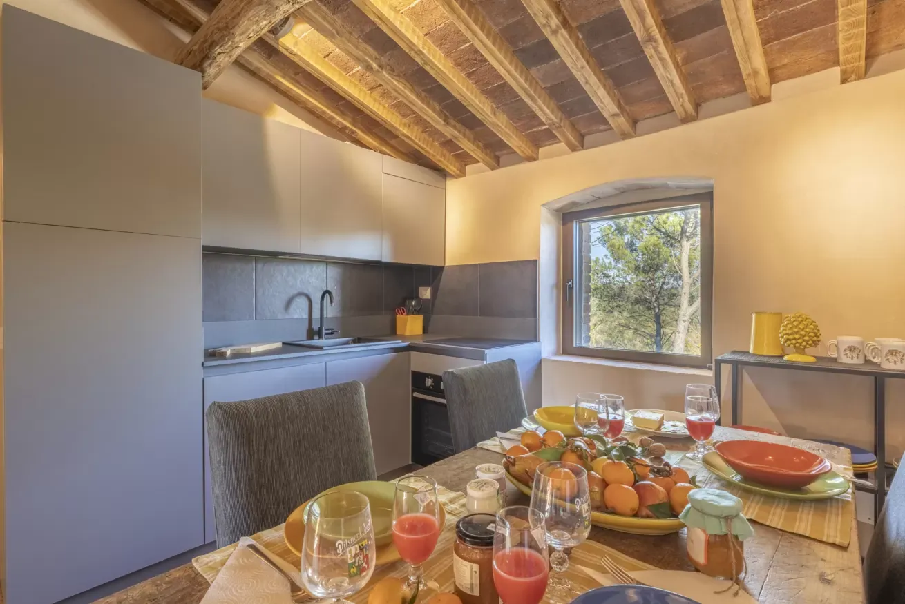 Cucina moderna con tavolo apparecchiato per la colazione e finestra con vista sugli alberi