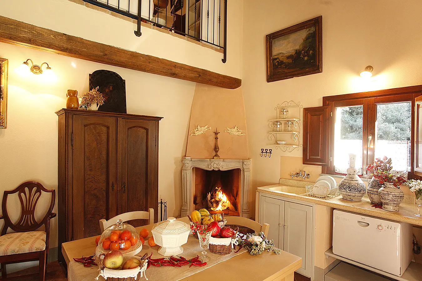 Cucina rustica con camino acceso, tavolo apparecchiato e finestra aperta