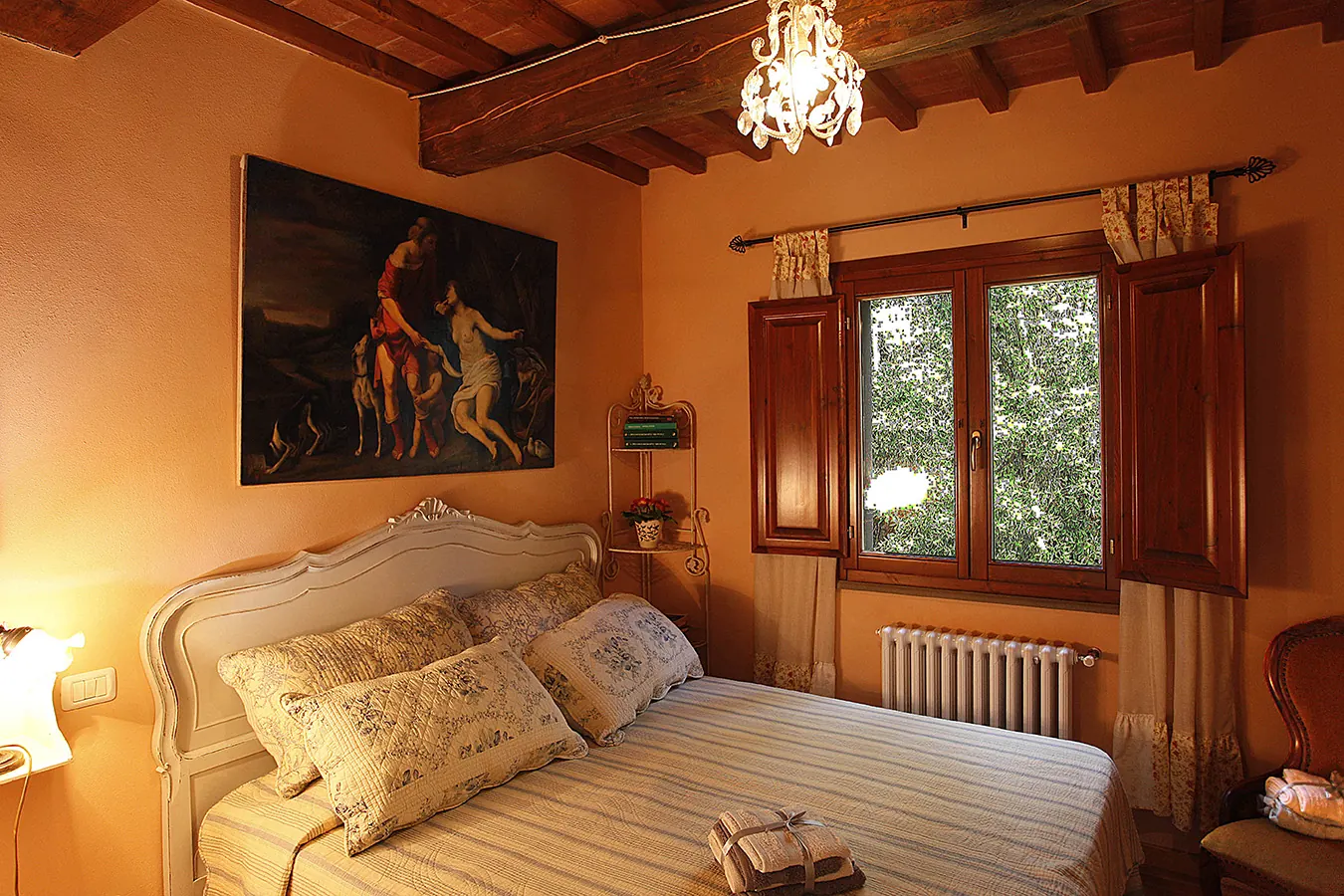 Camera da letto accogliente con letto matrimoniale, finestra in legno e lampadario